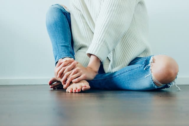 Acupuncture-Bristol-Peri-menopause lower half of women sitting on floor with hands on feet - acupuncture menopause